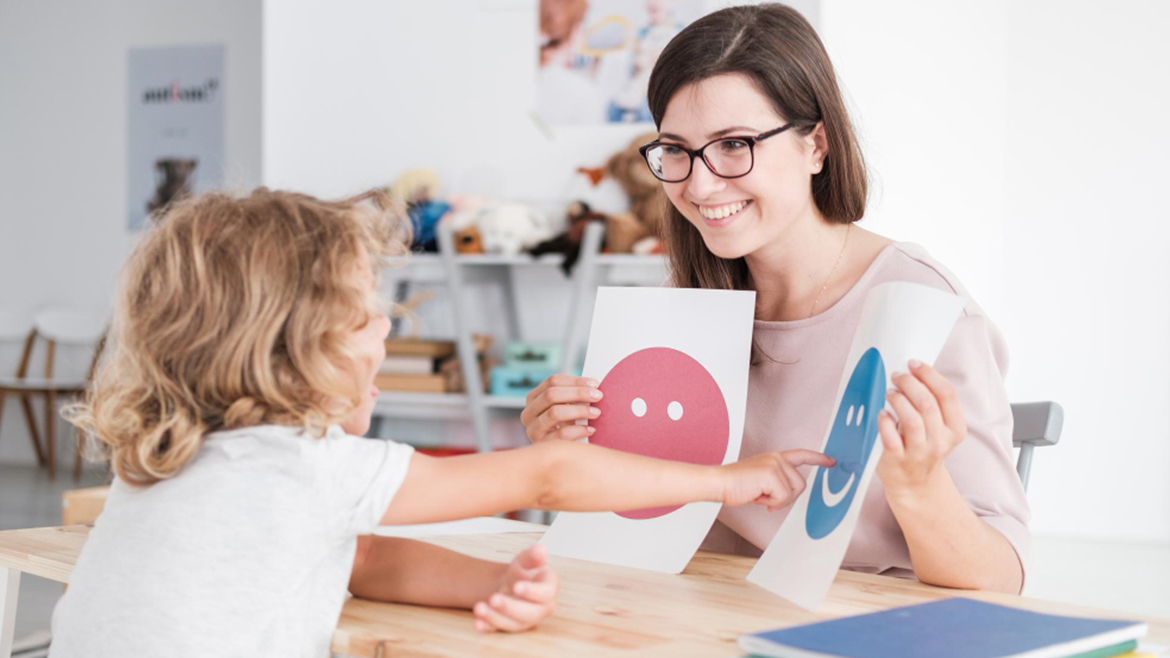 Terapista che lavora con un bambino usando carte delle emozioni